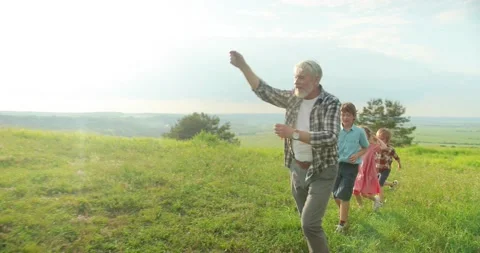 View from far on the happy and cheerful caucasian senior grandfather with three Stock Footage 157825399