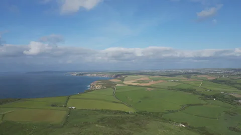 A view of the far stretching coastline with steep cliffs and green farmlands. Stock Footage 285309344