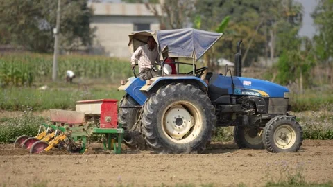View of a farmer operating a tractor in a field in Dhangadhi, Nepal. Video stock 335473359