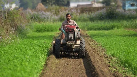 View of a farmer tilling soil with a power tiller in Nepalgunj, Nepal. Video stock 335468547