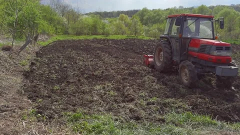 View of a farmer on a tractor plowing the soil. Agribusiness in the spring Stock Footage 198355949