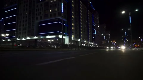 View of fast car moving on a night avenue in city, road with lights reflected on Stock Footage 133203547