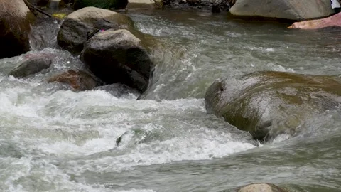 View of a fast flowing river over a collection of natural rocks. Stock Footage 327302391