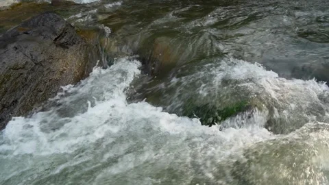 View of a fast flowing river over a collection of natural rocks. Stock Footage 327310212