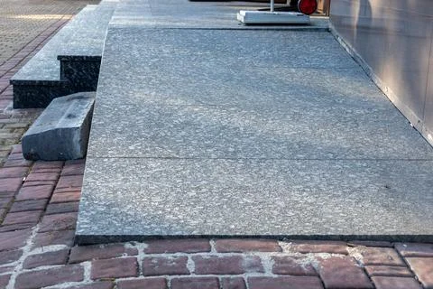 The view features a smooth gray stone sidewalk next to textured brick pavem.. Stock Photos