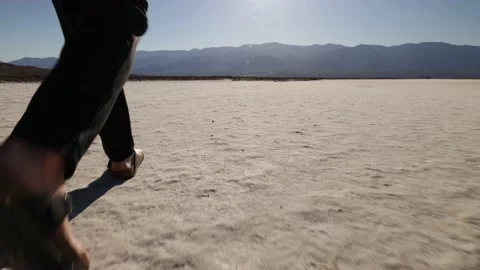 View Of Feet Walking In Dry Deserted Landscape With Bright Sun Stock-Footage 232179902