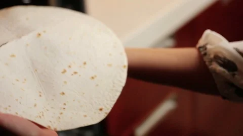 View of female hands putting a thin round pita inside the oven. Young woman Stock Footage 107446712