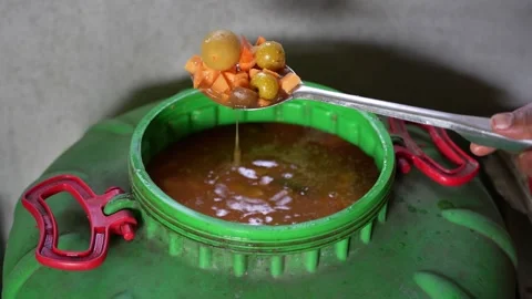 View of fermented fruit being scooped from a barrel, Nepal. Stock Footage 335603355