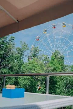 View of Ferris Wheel Overlooking Trees from Balcony on a Sunny Day Stock Photos