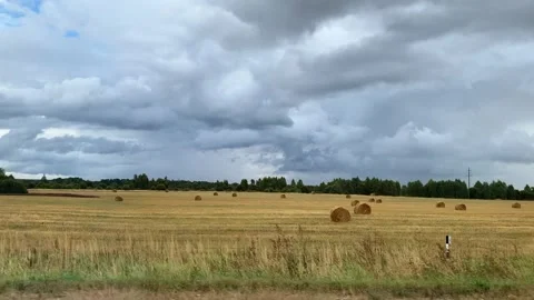 View of a field with haystacks from the window of a moving car. Stock Footage 162272826