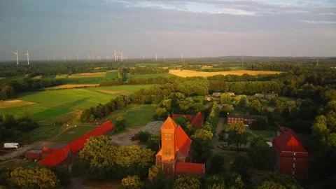 A view of fields and wind turbines near a rural area with a church in the f.. Stock Footage 339783033