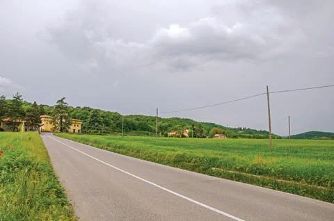 View of fields, empty road and a castle in Emilia-Romagna region countryside Stock Photos