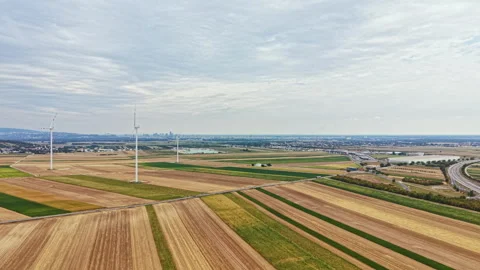 View of fields with wind turbines near a city during the day in a rural area Stock Footage 342785440