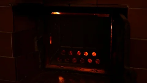 View of the fire through the circle holes on the stove door. Video stock 85432639