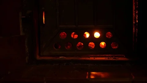 View of the fire through the circle holes on the stove door. 스톡 동영상 85436042