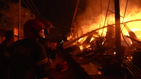 View of firefighters battling a large fire at night, Bangladesh. 스톡 동영상 335562369