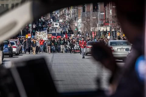 View of the First line of Protesters walking in the Street Through a Police Car  스톡 사진
