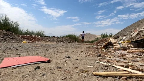 View from the floor of a man running away between garbage in the farmland in Cas 库存影片 197087664