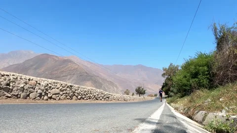 View from the floor of a man running on the road between mountains in the highla Vidéo 199546936