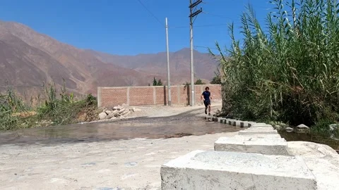 View from the floor of a man running on the side of a road with water on the roa Stock Footage 199548844