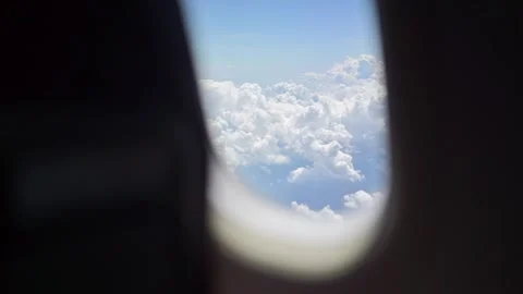 View of fluffy clouds from airplane window, blue sky overhead, serene aeria.. Stock Footage 339650029