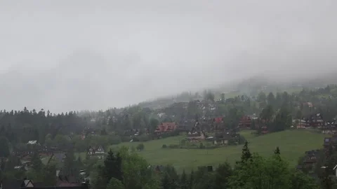 View of fog rolling over Tatra mountains onb a rainy day with small village.. Vídeos de archivo 329063532