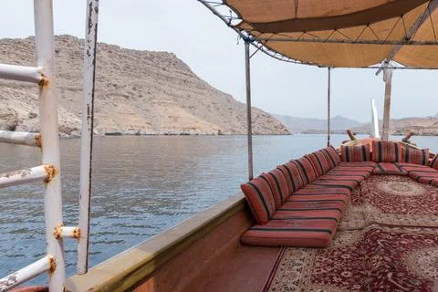 View fom the traditional arabian dhow boat sailing on the sea. Red pillows and Stock Photos