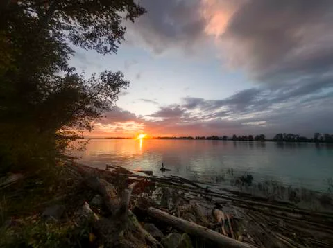 View from the forest to the amazing sunset over the river. Stock Photos