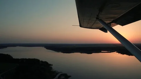 View of the forest, river and sunset from cockpit of Cessna pilot Stock Footage 80312816