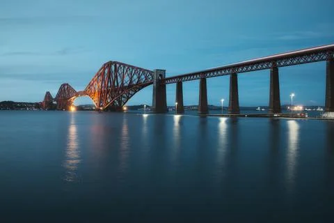 View of Forth Rail Bridge at night and and the glow trail of a moving train over Stock Photos
