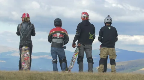 View of four longboard riders turned back standing on Transalpina Stock Footage 57785646