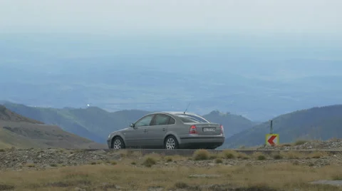 View of four longboarders riding behind a car on Transalpina Stock Footage 57786346