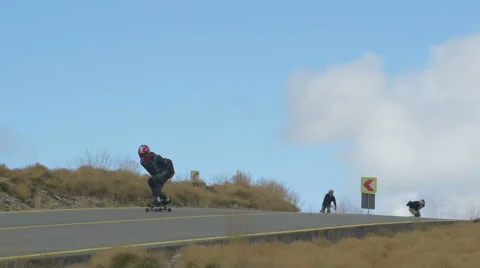 View of four longboarders riding down the road of Transalpina Stock Footage 57786047