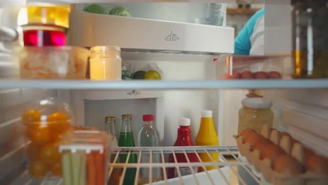 View from fridge of obese man taking ketchup from door shelf and putting in on Stock Footage 135664473