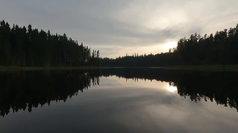 View from the front of a canoe as moving slowly through very calm evening pond Stock Footage 306094080