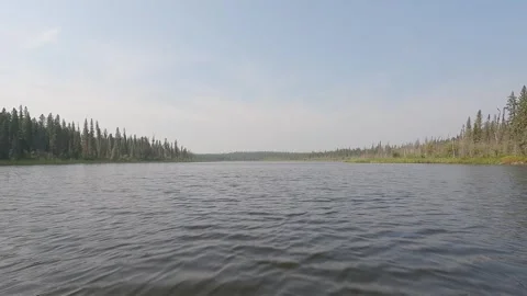 View from the front of a canoe while moving across a northern lake with light fo Stock Footage 300375978