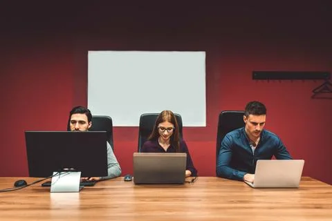 View from the front three colleagues, two man and a women working in the office Stock Photos
