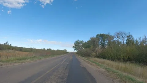 View from the front of a vehicle driving along a old paved road winding through Stock Footage 306093554