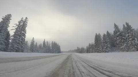 View from the front of a vehicle while driving along a snow-covered road through Stock Footage 323539150