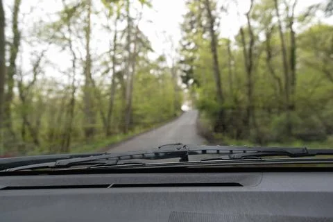 View from the front window of a car on a road in the forest Stock Photos