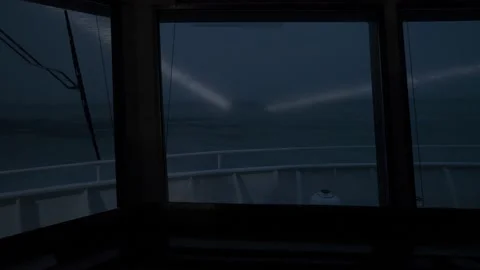 View from front windows of ship. Twilight. Searchlight beams shine forward on Stock Footage 234183742