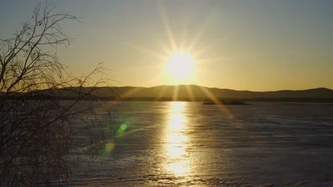 View of the frozen lake at sunset. Rays of the bright sun. Video stock 238527603