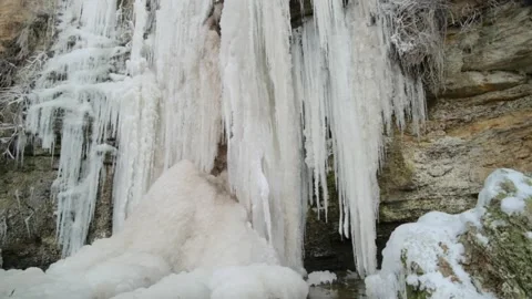 A view of the frozen streams of a small waterfall in winter Stock Footage 329012672