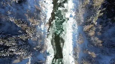 View of frozen winter river flowing through snowy forest Stock Footage 330740656