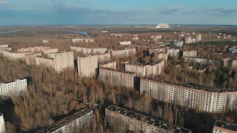 View of ghost city of Pripyat with Chernobyl nuclear power plant and sarcophagus Stock Footage 159265475
