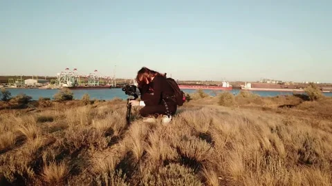 View of girl operator working with camera with stab on a windy fall hills Video stock 143559009