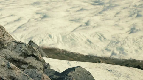 View of glacier with rocks in foreground and ice in background Stock Footage 343573778