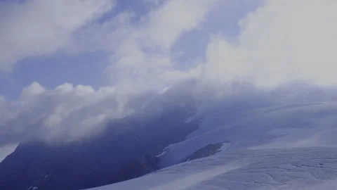 View of the glacier from the top of the mountain, covered with running clouds Stock Footage 318415061