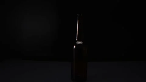 View of a glass bottle on a dark background Stock Footage