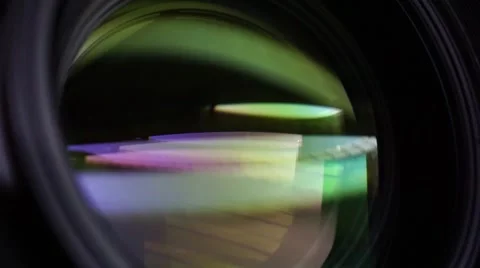 View of the glass elements in a camera lens. Objective under yellow light. Tilt Stock Footage 68172923